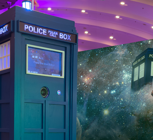 Nachbau der blauen Polizei-Rufbox aus der Serie Doctor Who, gestaltet als Fotobox mit Bildschirm und Kameraöffnung. Im Hintergrund eine Weltraumkulisse mit Sternennebeln.